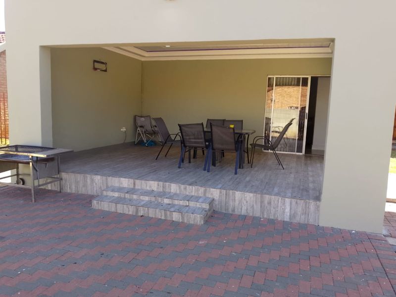 A covered outdoor patio featuring tiled flooring, recessed lighting, and direct access to the interior via a sliding glass door.