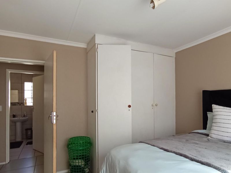 A bedroom featuring built-in wardrobes and direct access to an adjoining bathroom.