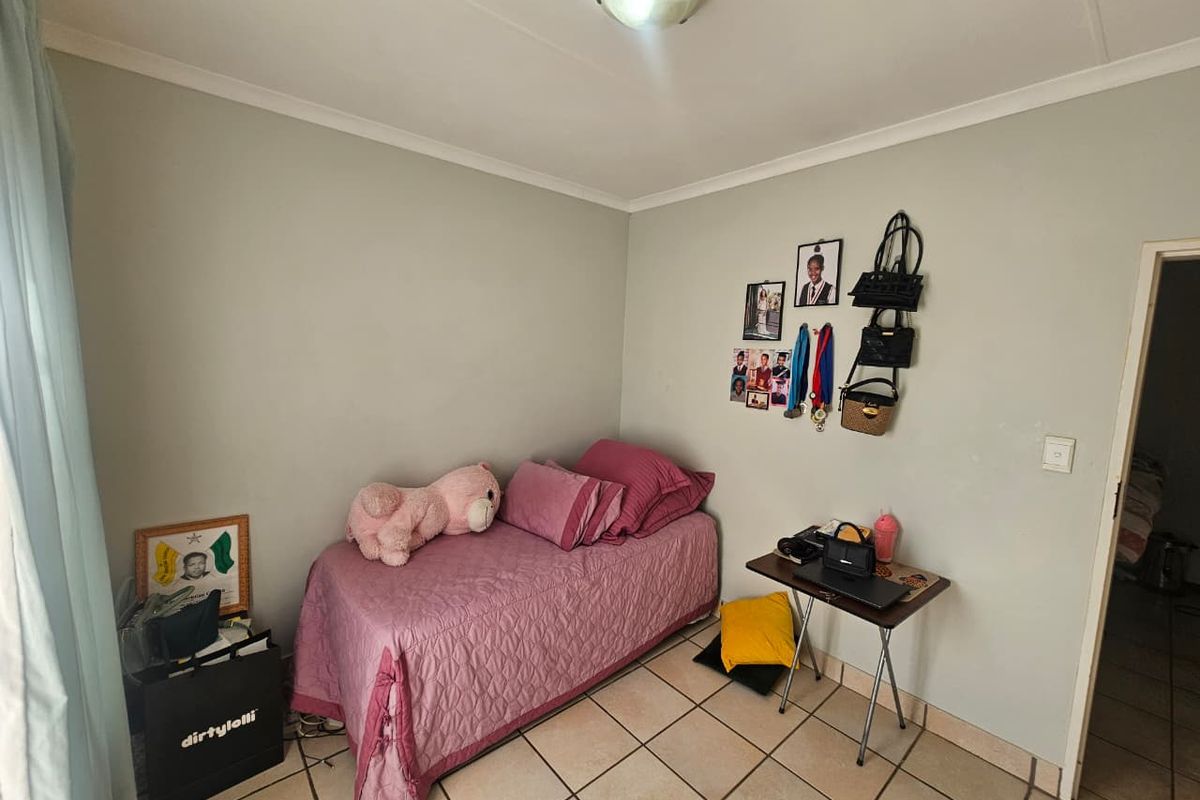 A functional bedroom featuring tiled flooring and neutral wall finishes, providing a clean and simple space.