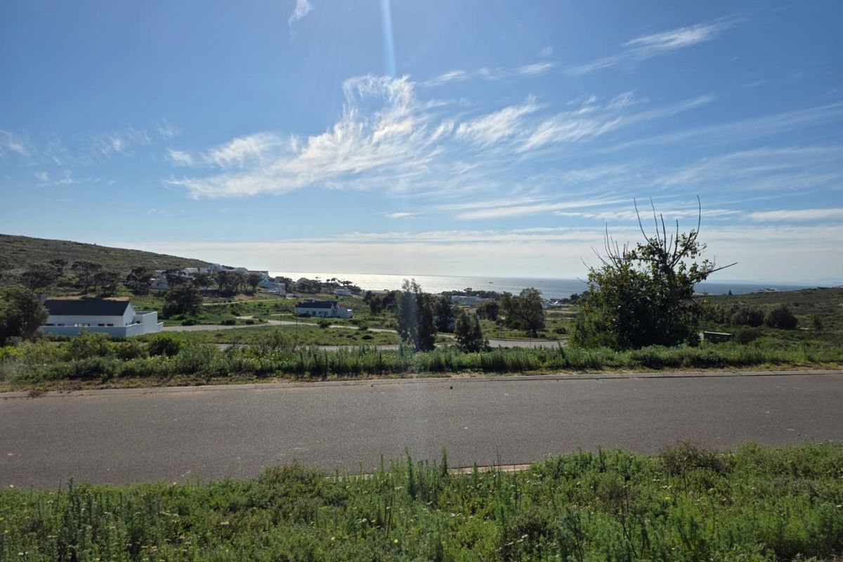 A scenic view overlooking the coastal landscape and surrounding residential area from the perspective of the vacant land.