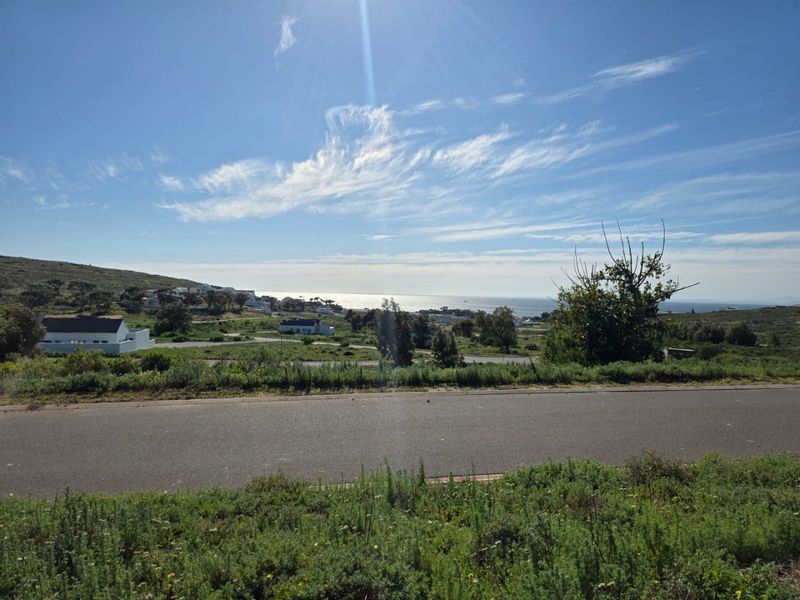 A scenic view overlooking the coastal landscape and surrounding residential area from the perspective of the vacant land.