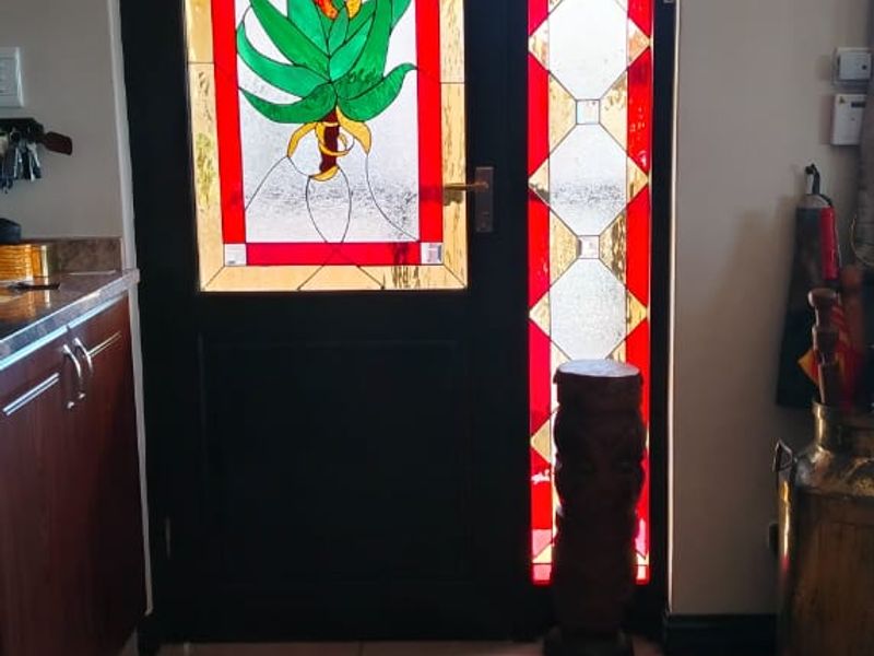 Entrance area featuring a decorative stained glass front door and tiled flooring, providing a unique character to the home's entry point.