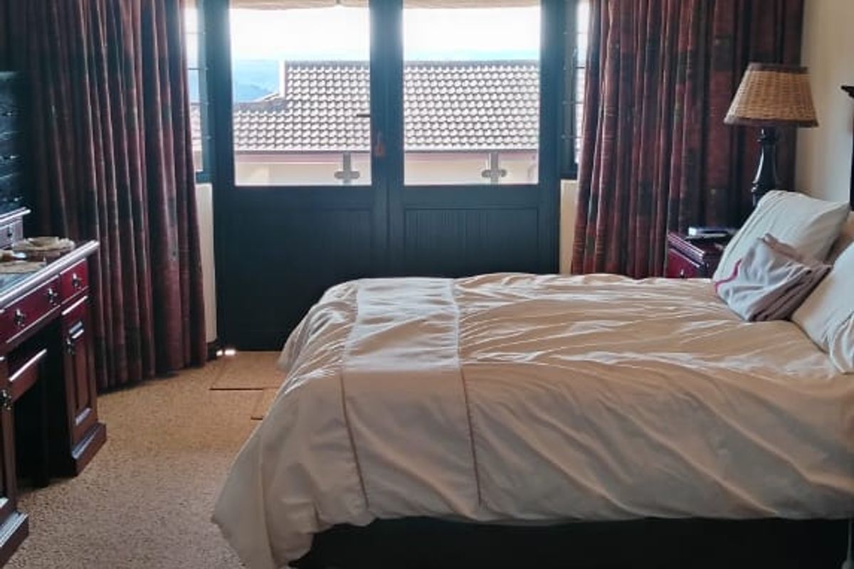 A carpeted bedroom featuring recessed downlighting and double glass doors that open to an exterior view.
