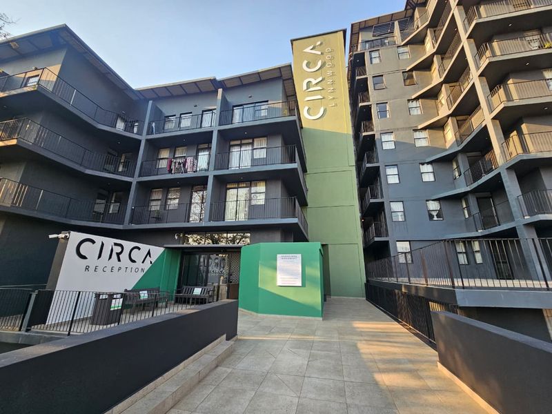 Exterior view of the Circa Lynnwood apartment complex, featuring modern multi-story architecture with balconies and a paved entrance area.