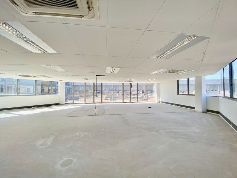Spacious open-plan commercial office space featuring large windows, suspended ceilings with recessed lighting, and ducted air conditioning, ready for custom flooring and fit-out.