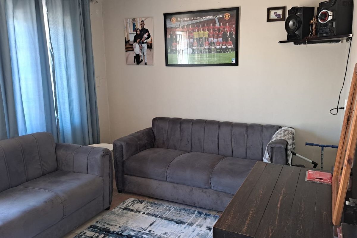 A standard living room area featuring tiled flooring and neutral wall finishes, providing a functional space for relaxation.