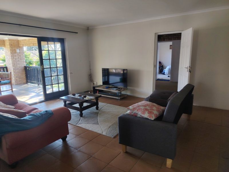 A living room featuring tiled flooring and a sliding glass door providing access to an outdoor patio area.