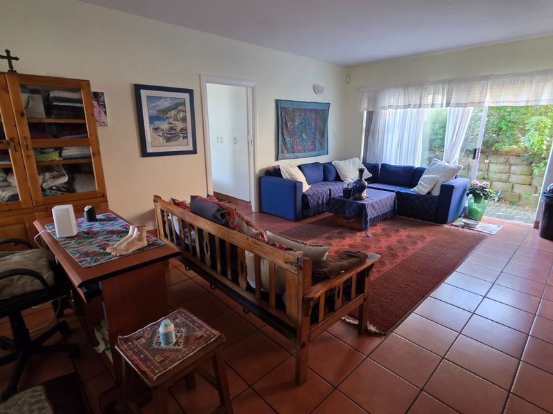 Open plan living area featuring tiled flooring and a sliding glass door providing access to the rear garden area.