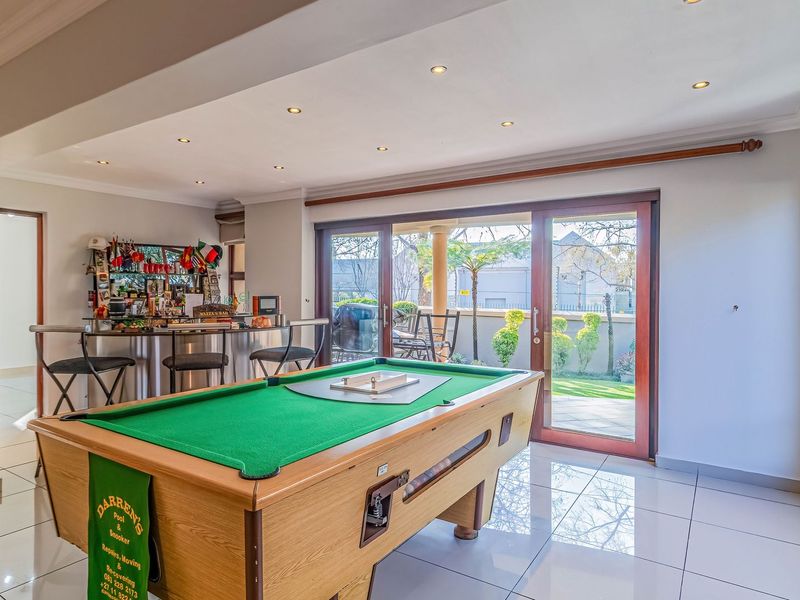 Spacious living area featuring tiled floors, recessed lighting, and large sliding glass doors providing seamless access to the outdoor patio and garden.