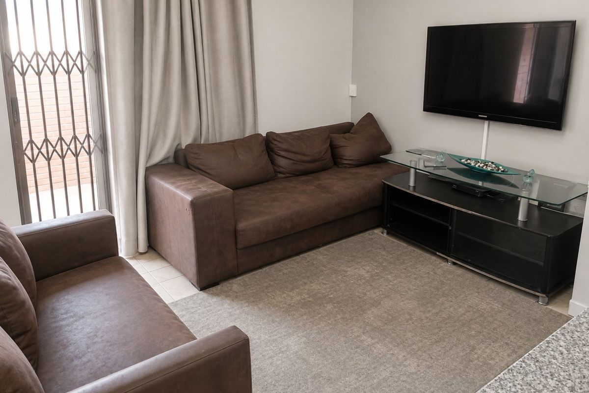 A functional living room featuring tiled flooring and a security gate leading to an outdoor area.