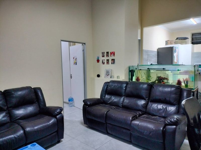 Open plan living area featuring tiled flooring and a view into the adjacent kitchen space.