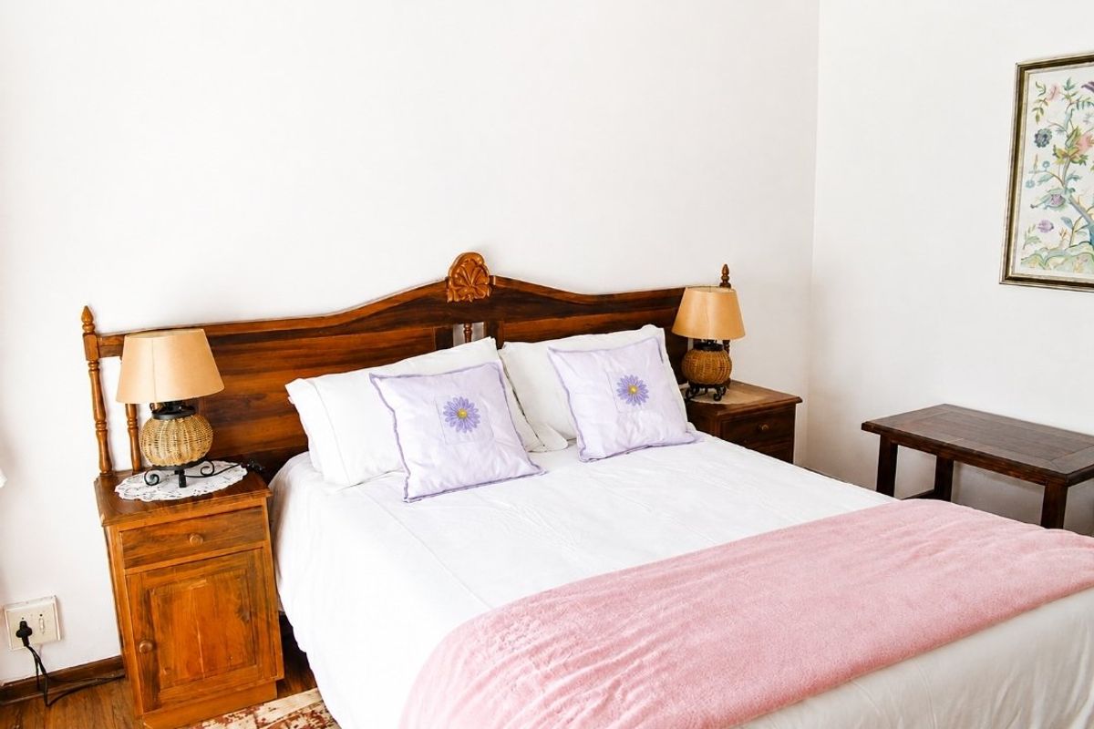A bedroom featuring neutral walls and wooden flooring, providing a simple and functional sleeping space.