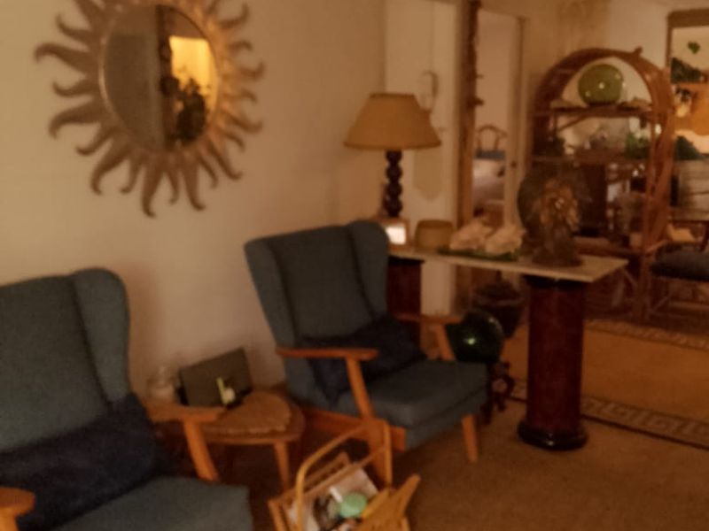 A living room area featuring a ceiling fan and neutral wall finishes, providing a comfortable space for relaxation.