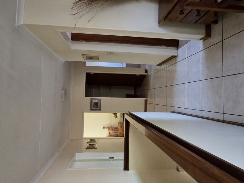 A functional hallway with tiled flooring and neutral walls, providing access to multiple rooms within the townhouse.