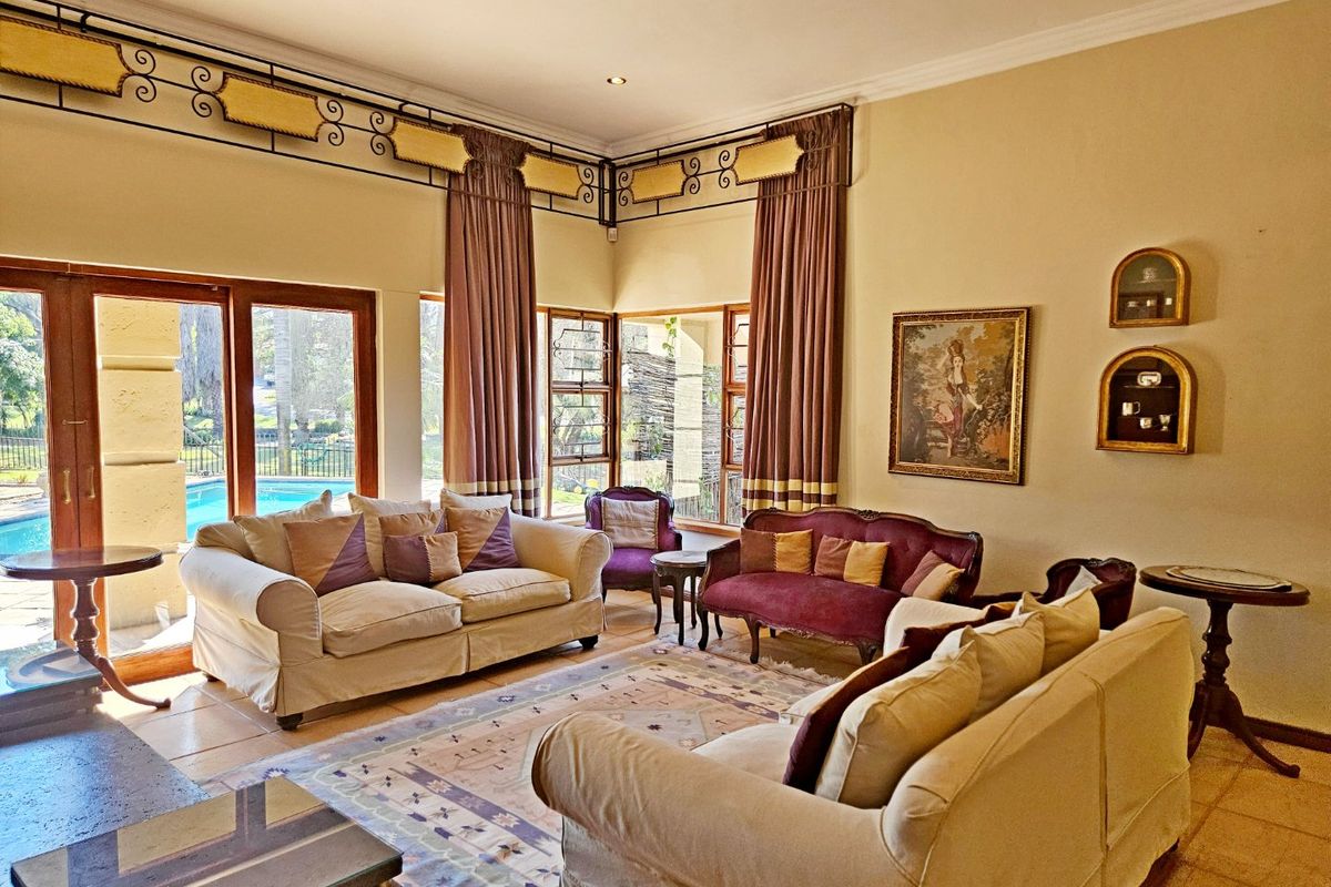Spacious living room featuring tiled flooring, recessed lighting, and large sliding glass doors providing direct access to the outdoor pool area.