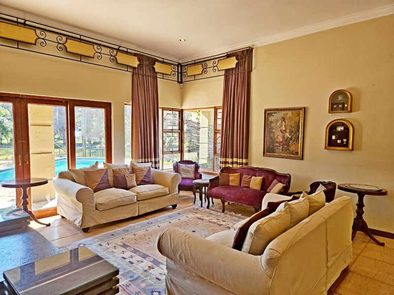 Spacious living room featuring tiled flooring, recessed lighting, and large sliding glass doors providing direct access to the outdoor pool area.