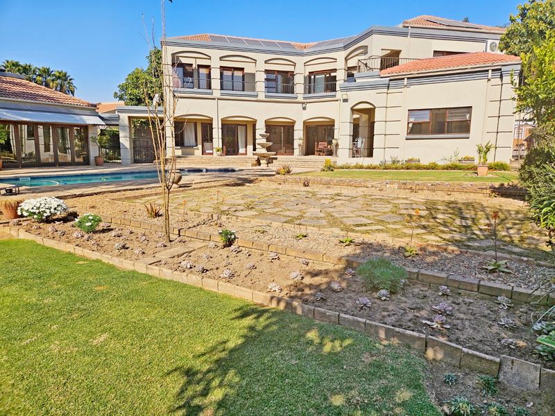 Spacious rear exterior featuring a large swimming pool, stone-paved patio area, multi-level terrace, and a well-maintained two-story residential facade.