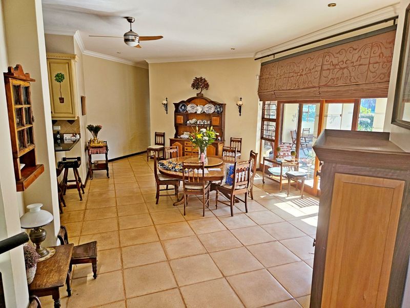 Spacious open-plan living and dining area featuring tiled flooring, recessed lighting, and large sliding glass doors providing access to the outdoor patio.