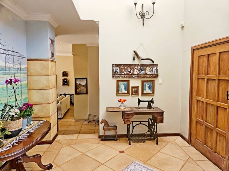 Spacious entrance hall featuring tiled flooring, a solid wood panel door, and decorative wall finishes leading into the main living area.