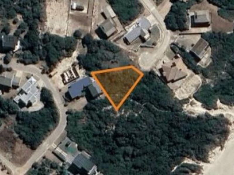Aerial view of a vacant residential plot situated in a coastal neighborhood, highlighting the property boundaries and surrounding landscape.
