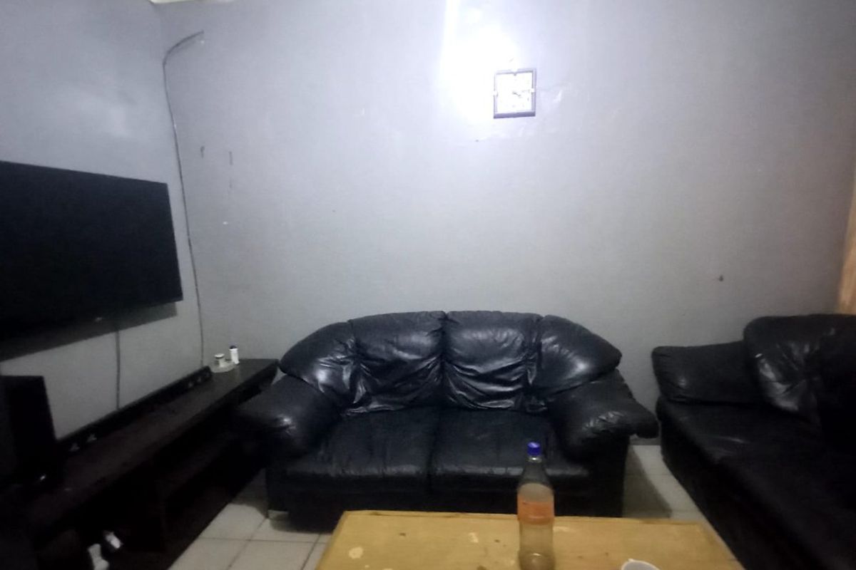 A living room featuring tiled flooring and coved ceilings, currently requiring cosmetic updates to improve the overall finish and presentation.