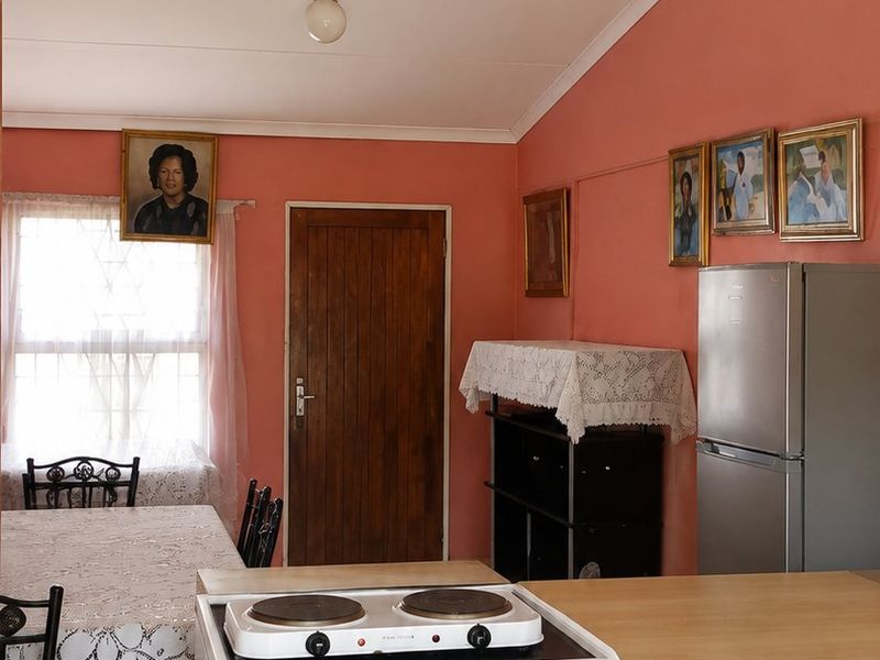 Open plan kitchen and dining area featuring a freestanding stove, tiled flooring, and timber door access.
