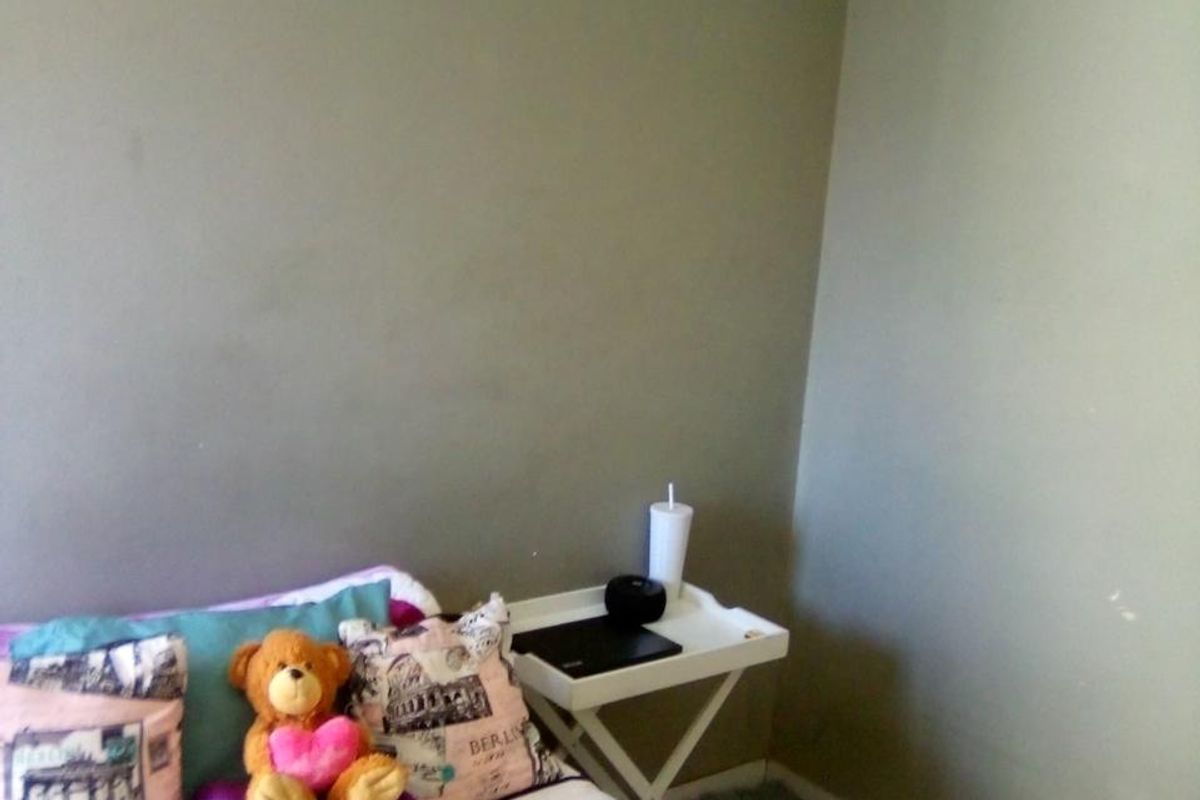 A compact bedroom featuring neutral wall tones and carpeted flooring, offering a blank canvas for personalization and interior updates.