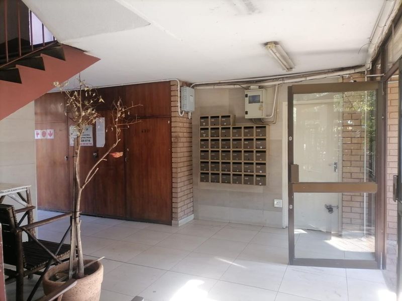 Apartment building entrance lobby featuring tiled flooring, a bank of mailboxes, and access to the staircase.