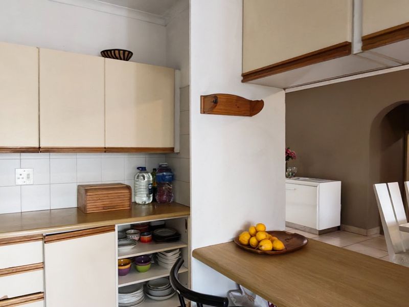 A functional kitchen featuring laminate countertops, ample built-in cabinetry, and a breakfast bar, with an open flow into the adjacent dining area.