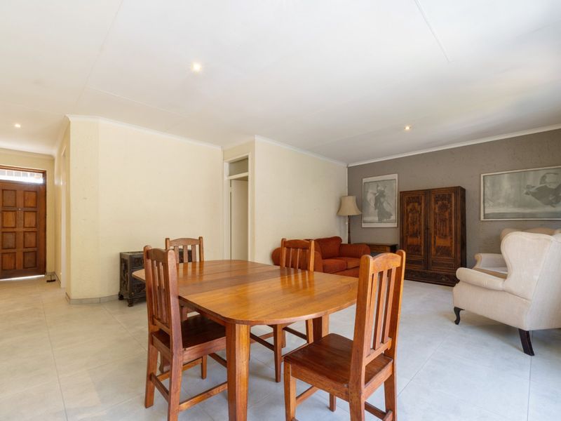 Spacious open-plan living and dining area featuring neutral wall finishes, tiled flooring, and recessed lighting, providing a versatile layout for modern living.