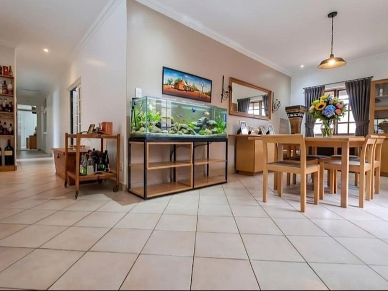 Spacious dining area featuring neutral ceramic floor tiles, recessed lighting, and built-in cabinetry, offering a functional and well-maintained living space.