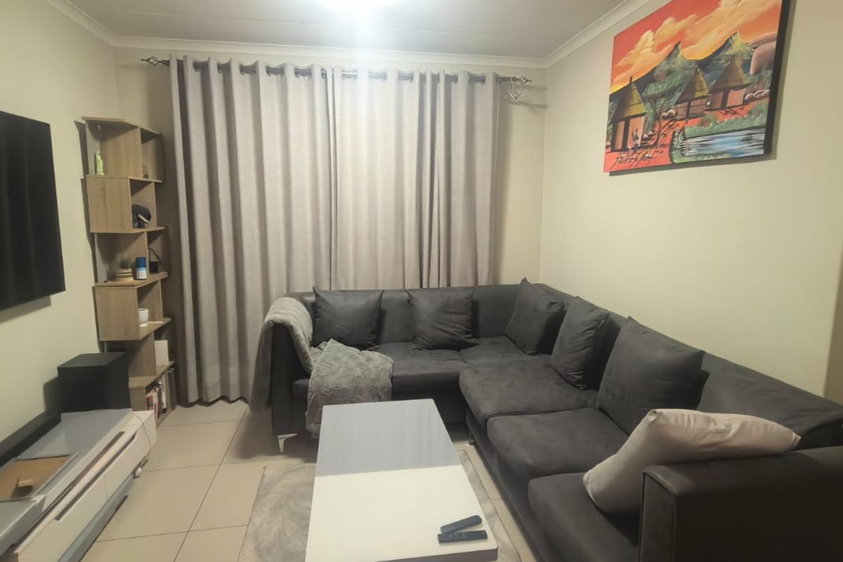 A comfortable living room featuring tiled flooring and neutral wall finishes, providing a functional and well-maintained space for relaxation.