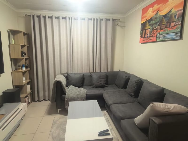 A comfortable living room featuring tiled flooring and neutral wall finishes, providing a functional and well-maintained space for relaxation.