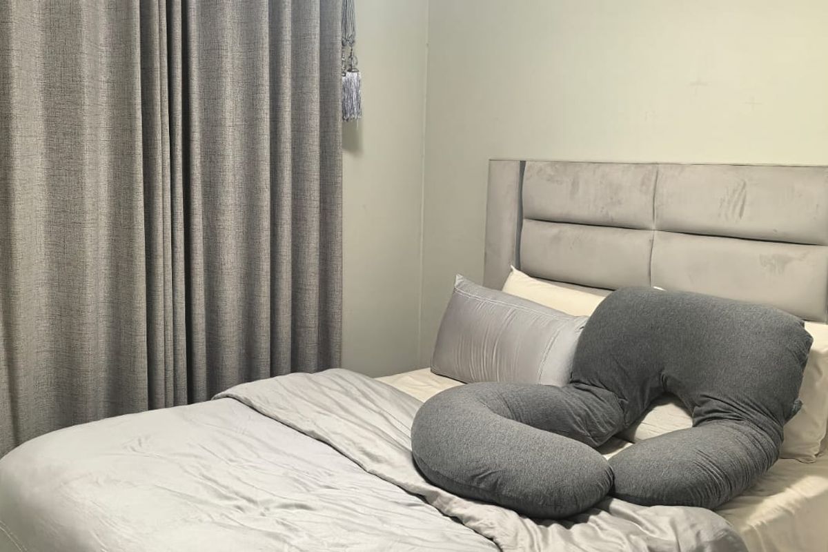A bedroom featuring neutral wall finishes and full-length curtains.