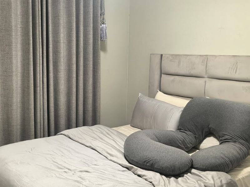 A bedroom featuring neutral wall finishes and full-length curtains.