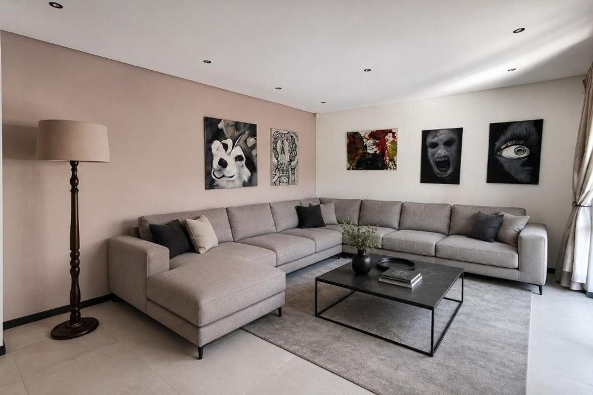 A well-maintained living room featuring neutral tiled flooring and recessed downlighting, creating a clean and modern atmosphere.