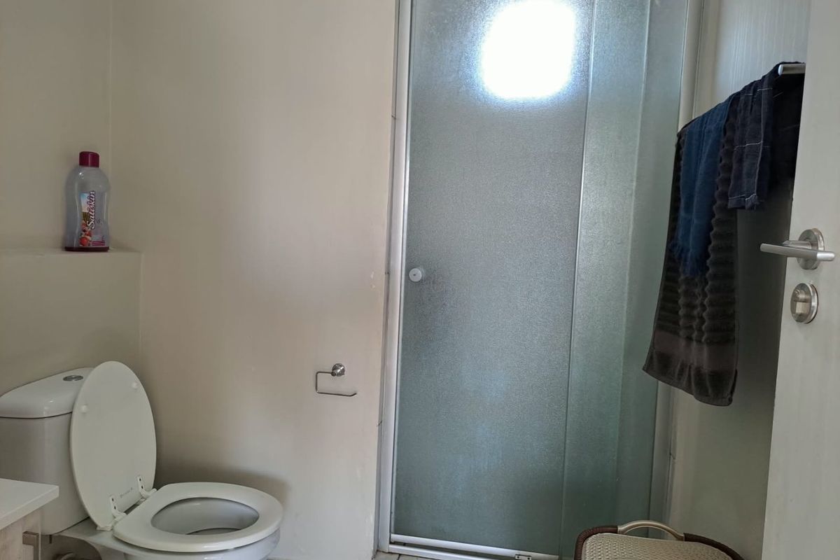 A functional bathroom featuring a shower enclosure and a standard toilet, providing essential sanitary facilities.
