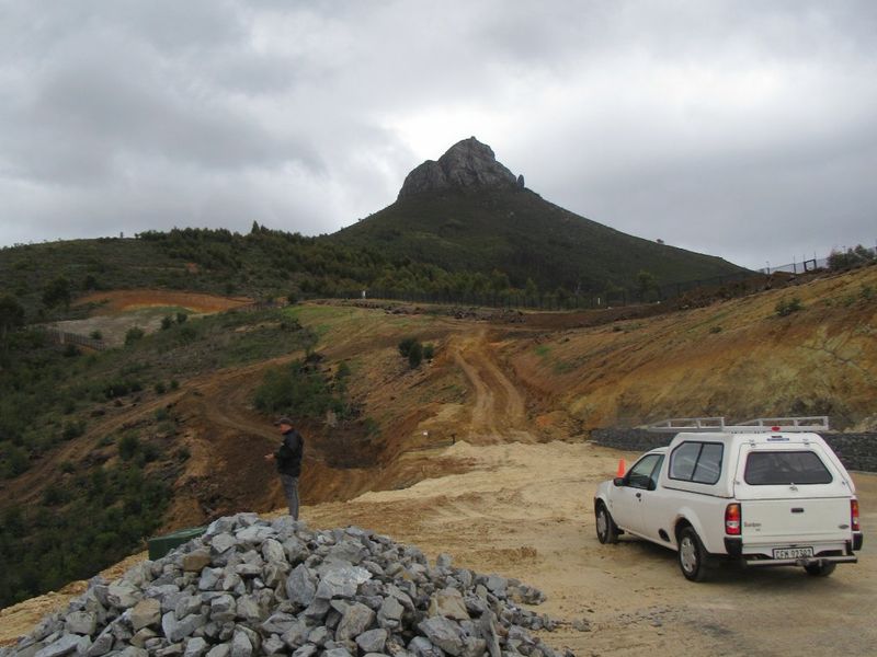 A view of a vacant residential plot featuring unpaved access and prominent mountain views, currently in a raw, undeveloped state.