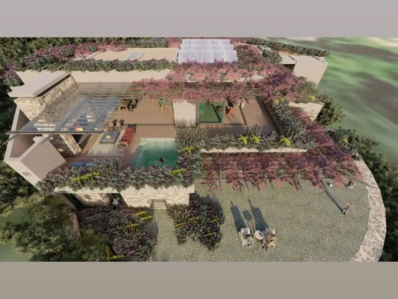 An aerial perspective of a luxury residential property featuring a swimming pool, expansive decking, and landscaped gardens.