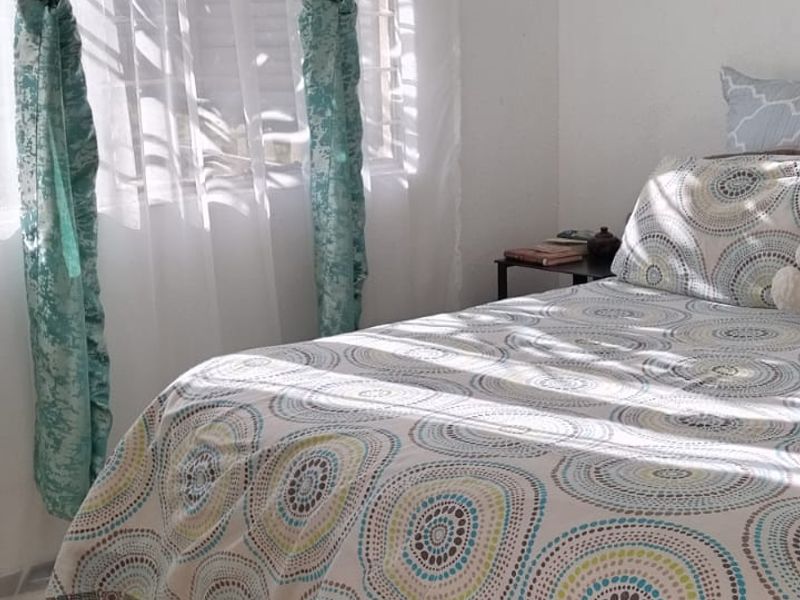 A bedroom featuring parquet flooring and natural light from a window.