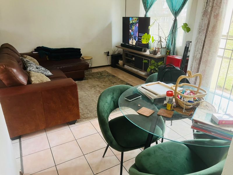 Open plan living and dining area featuring tiled flooring and access to an outdoor space through a sliding glass door.