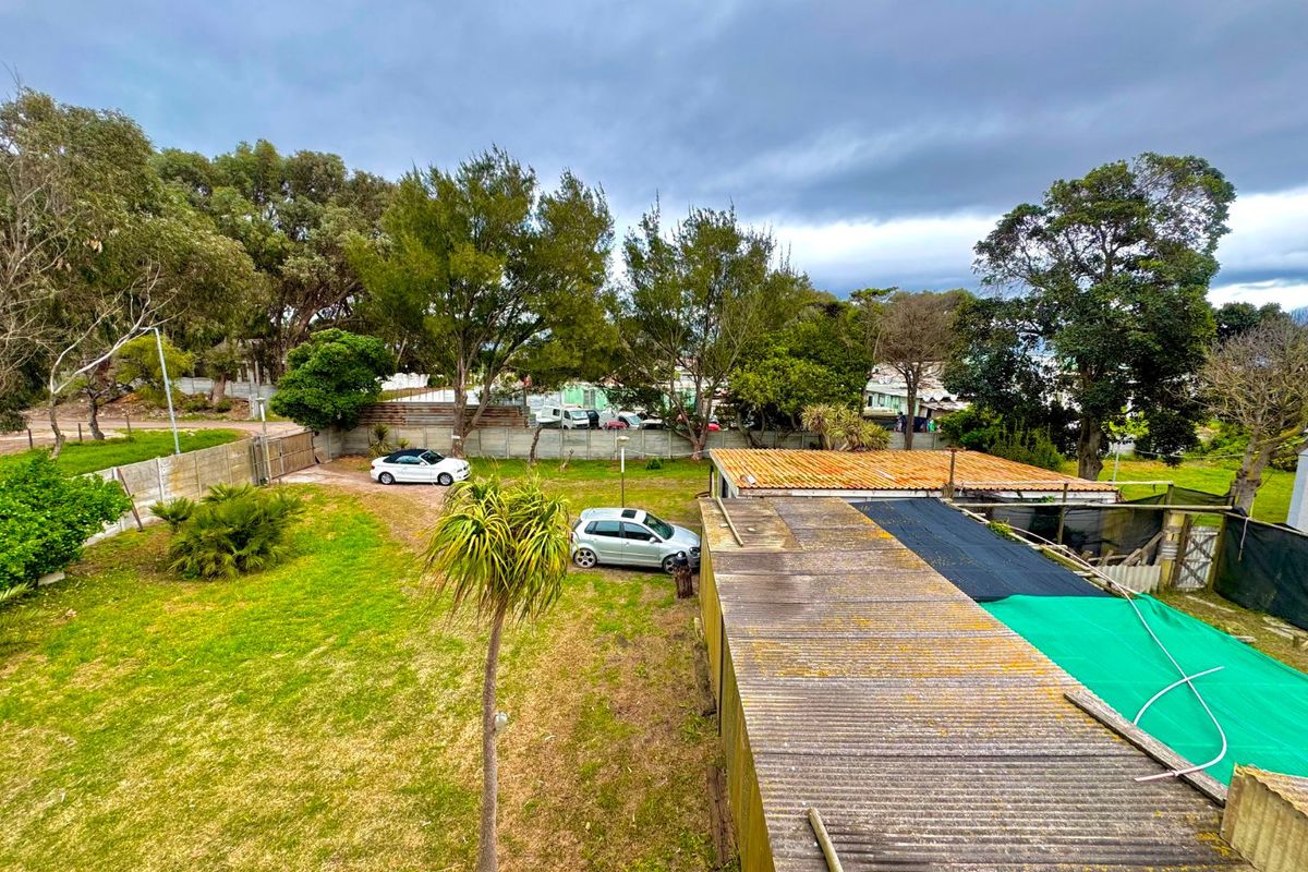 Aerial view of the property grounds featuring a large garden, driveway, and corrugated iron roofing on the outbuilding.