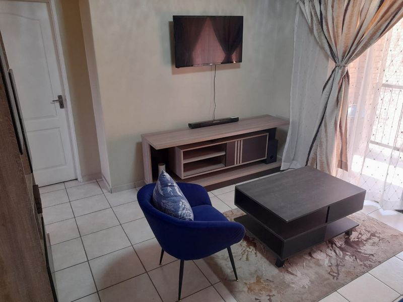 A living room area featuring tiled flooring and a sliding door leading to an outdoor space.