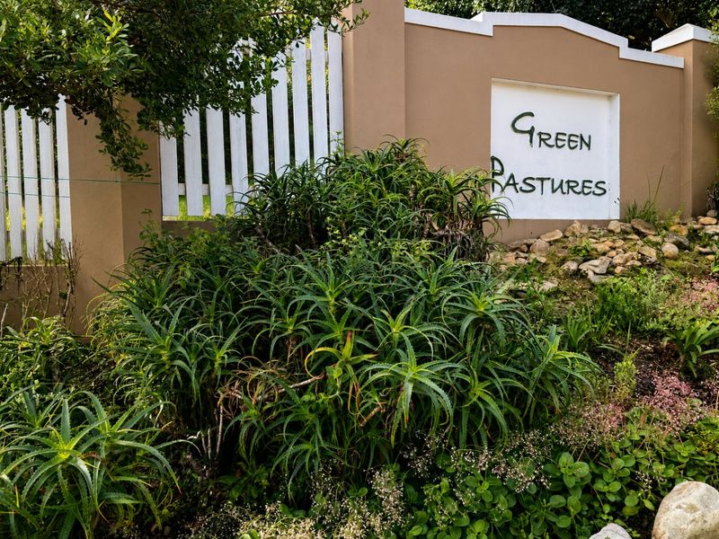 A well-maintained entrance wall and picket fence featuring established aloe plants and garden landscaping at the Green Pastures property entrance.