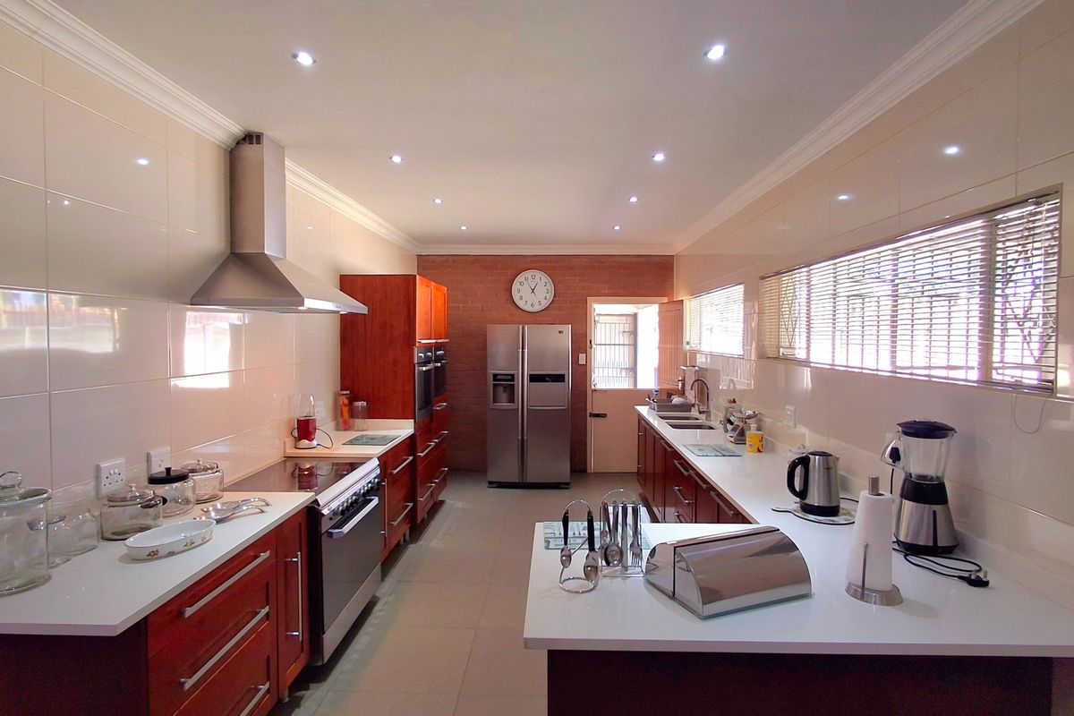 A spacious, well-lit kitchen featuring modern cabinetry, stone countertops, integrated stainless steel appliances, and a functional layout with ample workspace.