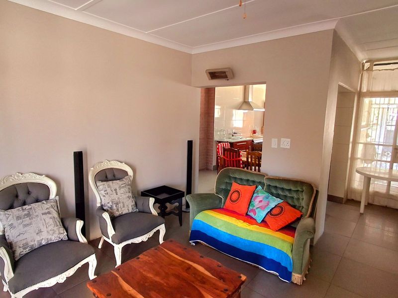 Open plan living area featuring neutral wall tones, tiled flooring, and a view through to the kitchen area.