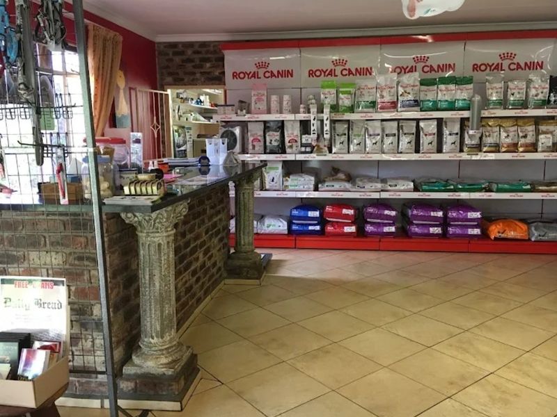 A commercial retail space featuring a brick service counter with decorative columns, tiled flooring, and extensive built-in shelving units.