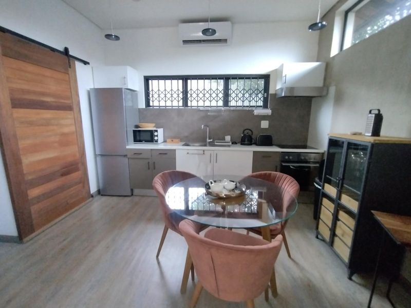 Modern kitchen featuring built-in cabinetry, stainless steel appliances, a sliding barn door, and a split-system air conditioner.