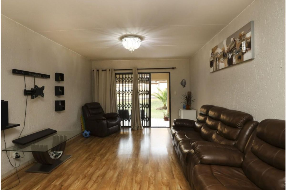 A comfortable living room featuring laminate flooring and a sliding glass door that provides direct access to the outdoor patio area.