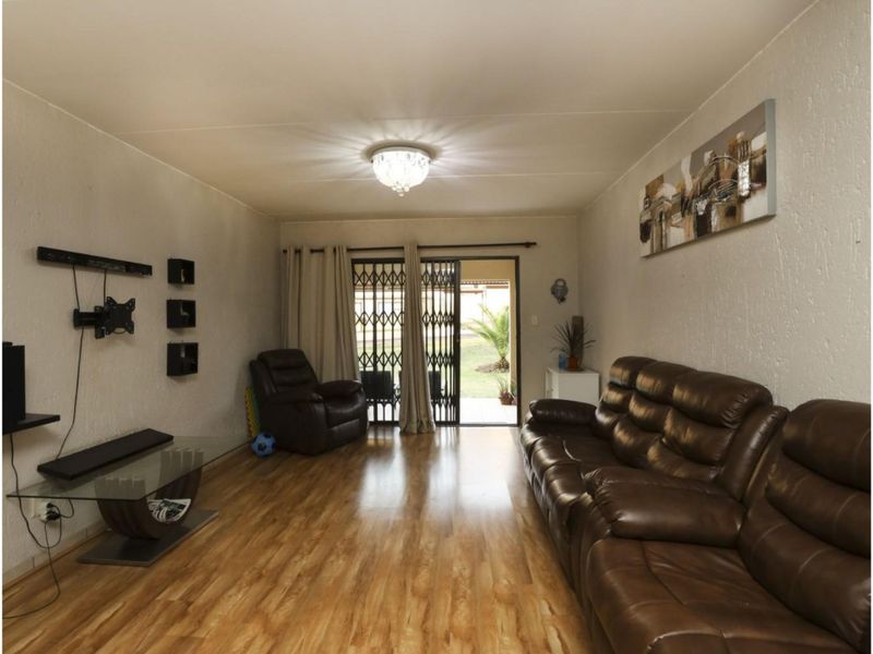 A comfortable living room featuring laminate flooring and a sliding glass door that provides direct access to the outdoor patio area.